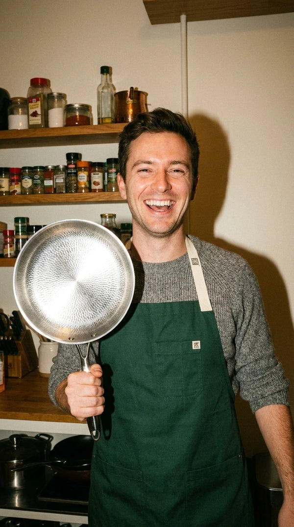 Holding up a Siraat Titanium Hammered Pan Pro in the kitchen